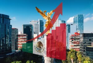 The image shows the Angel of Independence in Mexico City with rising bar graphs and an upward arrow, featuring a semi-transparent Mexican flag overlay. High-rise buildings are visible in the background.