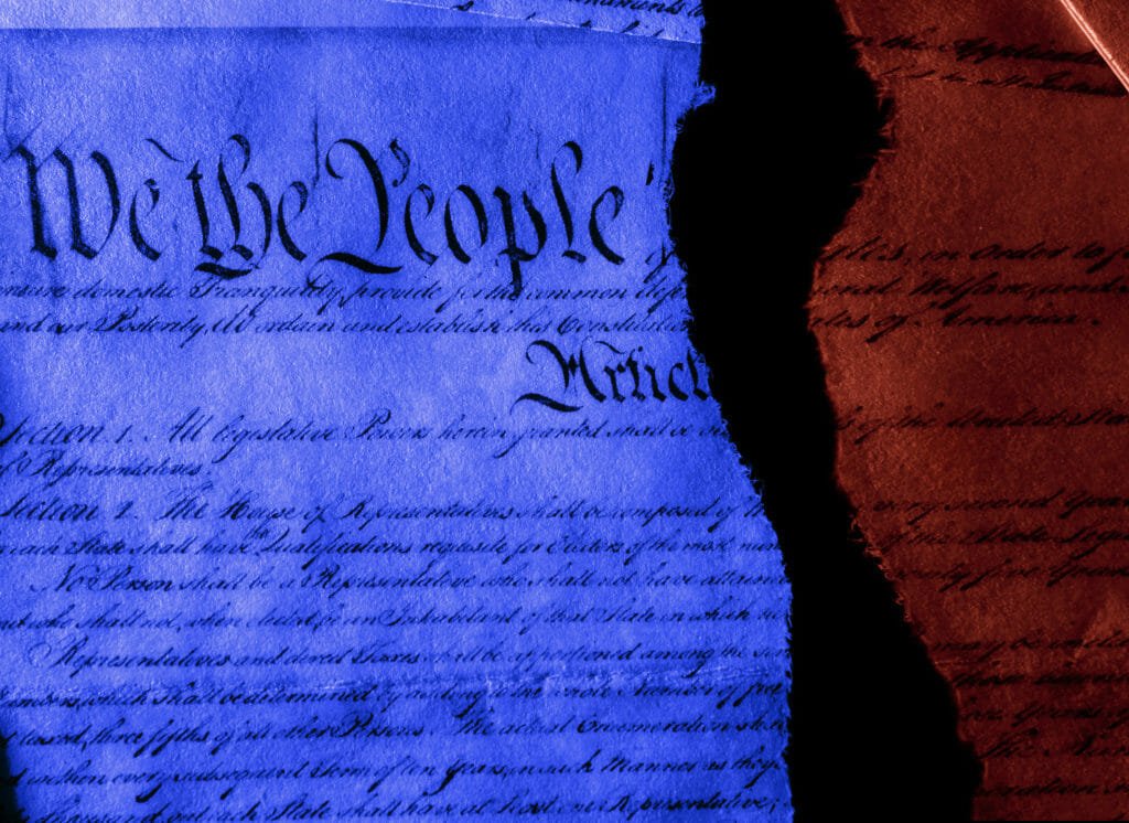 La Constitución de los Estados Unidos en rojo y azul partida por la mitad representando la división entre demócratas y republicanos.