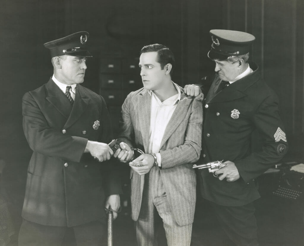 BW photo of two old time police arresting a man