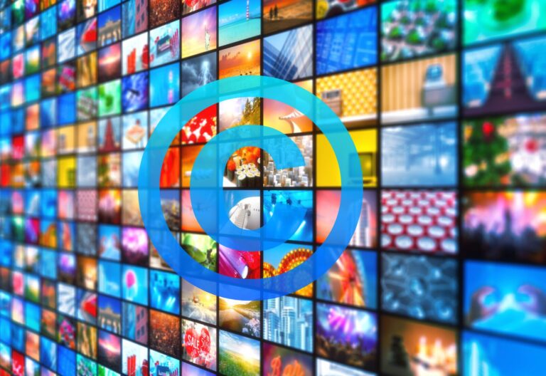 A large wall of multiple colorful video screens displaying diverse images, overlaid with a translucent blue concentric circle pattern at the center.
