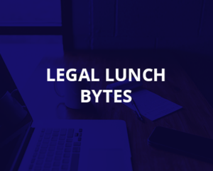 Escritorio de oficina con un ordenador y documentos durante una pausa de trabajo titulada &#039;almuerzo legal bytes&#039;.