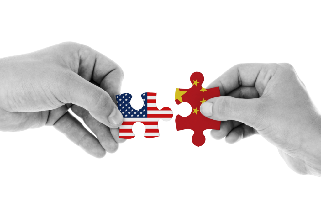 dos personas sosteniendo rompecabezas con bandera china y americana