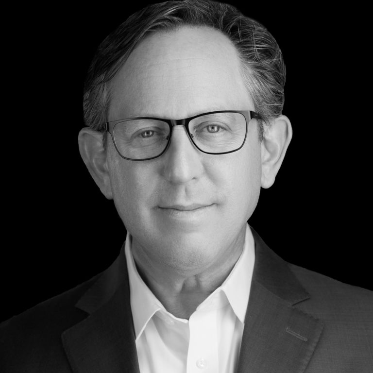 A black and white photo of a man wearing glasses.